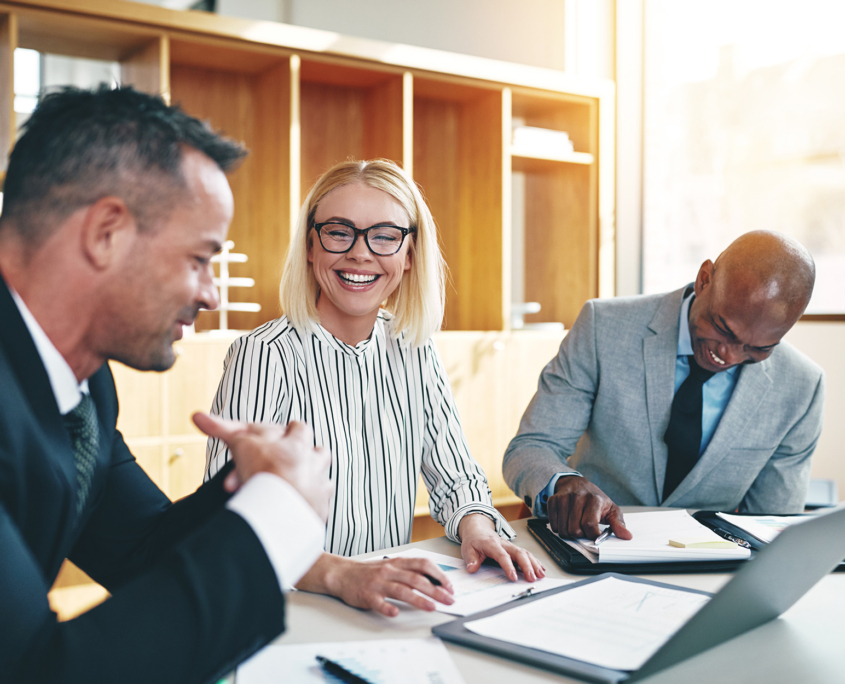 Diverse group of businesspeople laughing during a meeting.